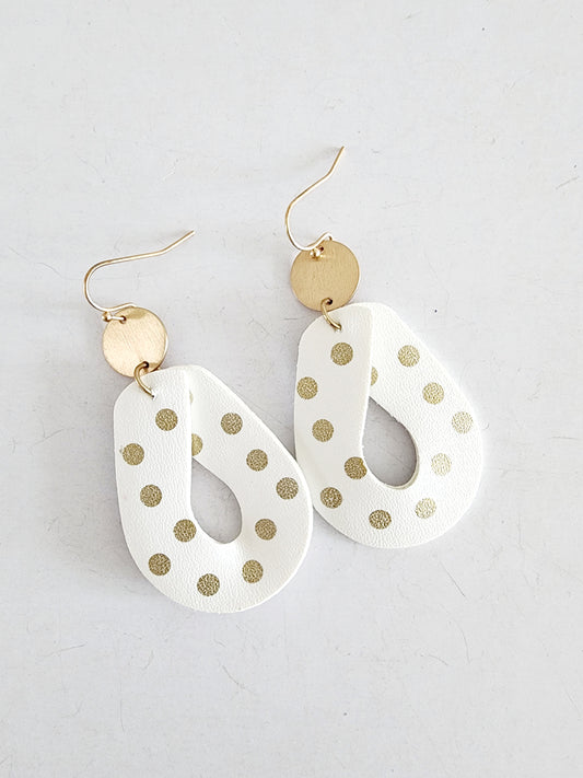 Drop-shaped leather earring with gold dots.